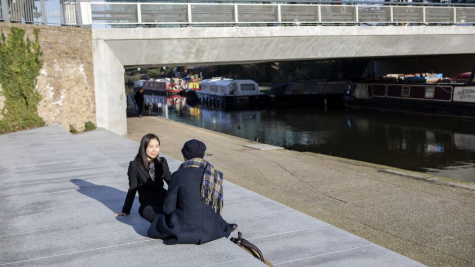 students sitting outside by the canal