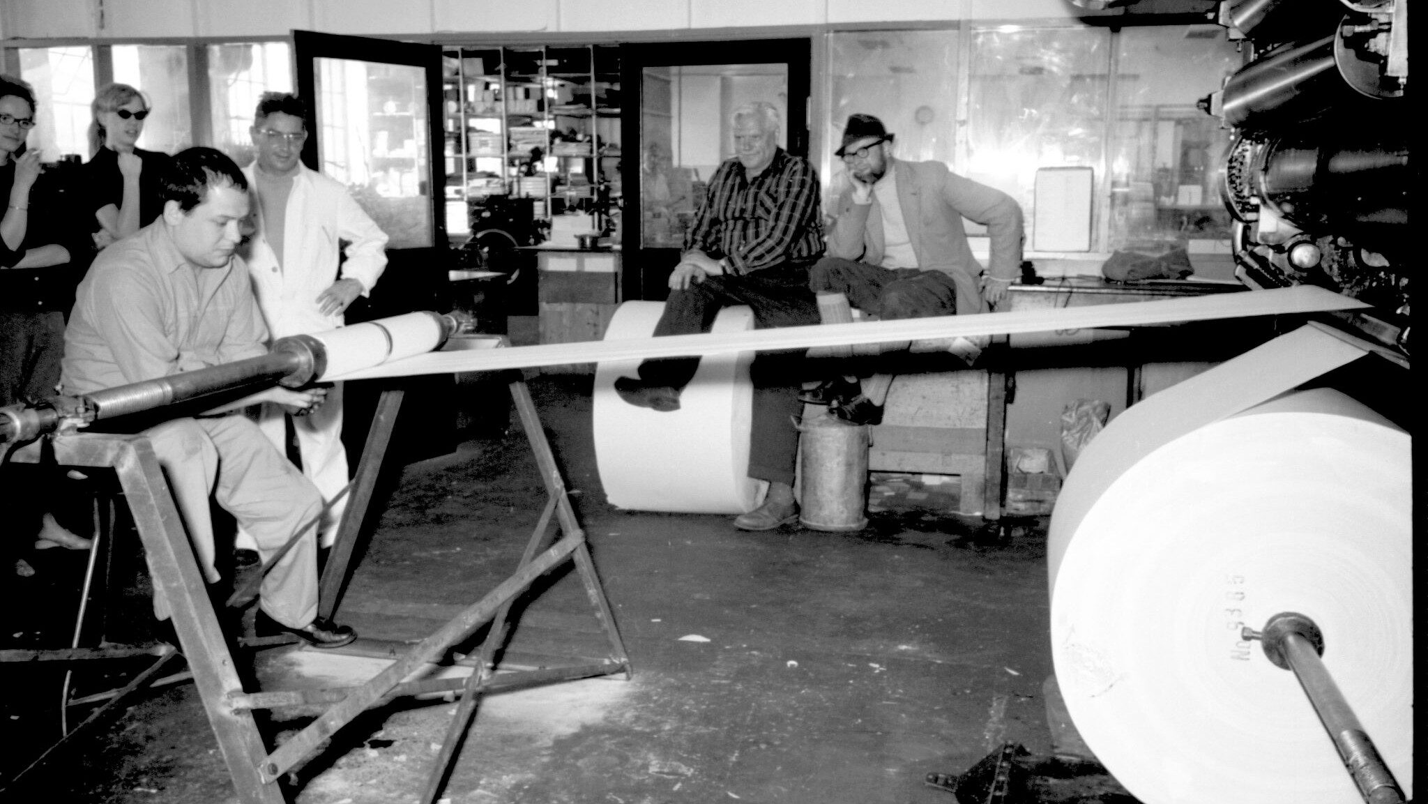 Black and white photograph of Manzoni making a scroll