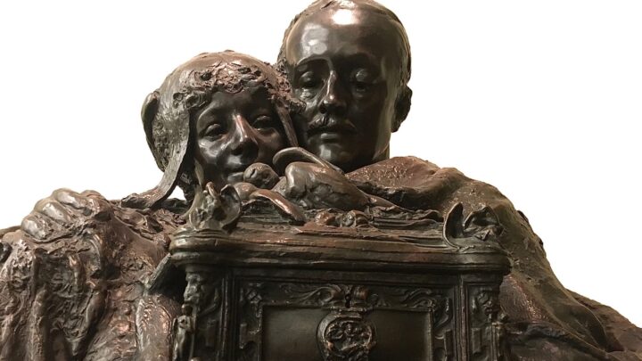 Sculpture of couple holding the casket