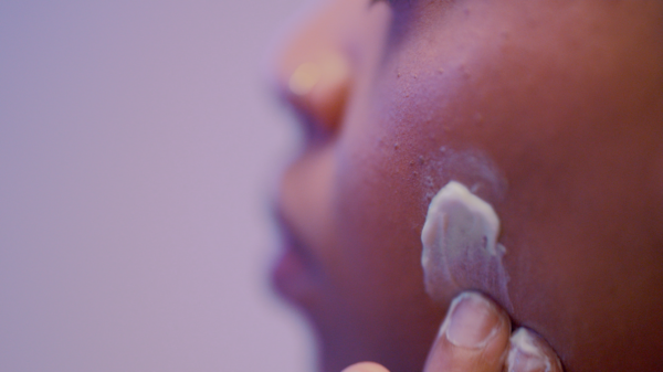 Photo of person rubbing white cream on face
