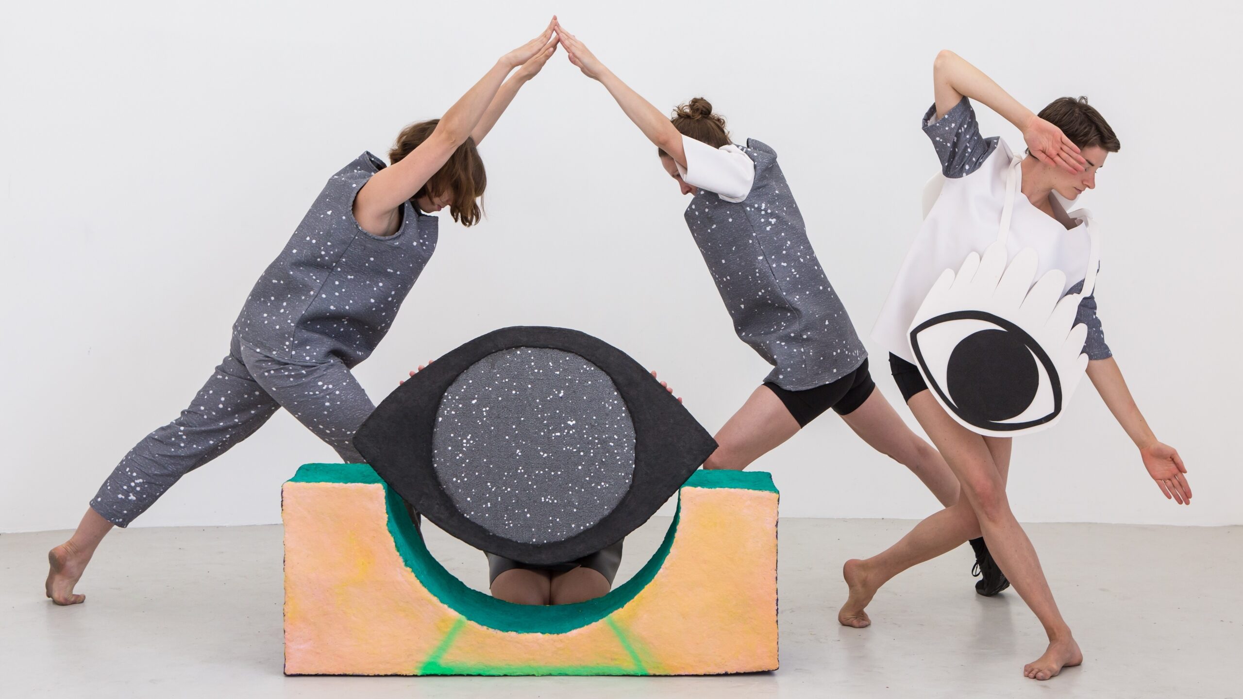 People dancing in costume to make an eye shape