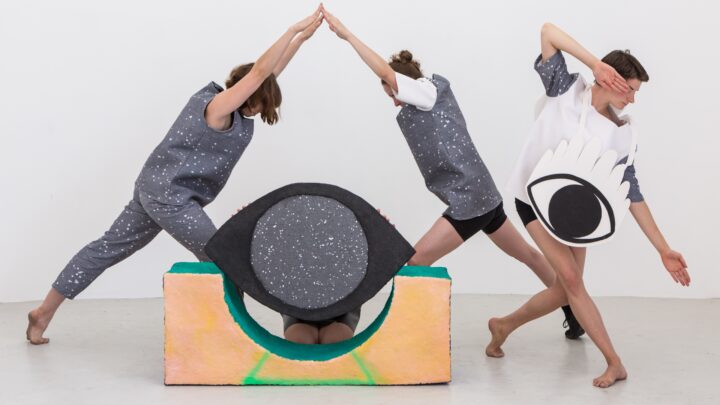 People dancing in costume to make an eye shape