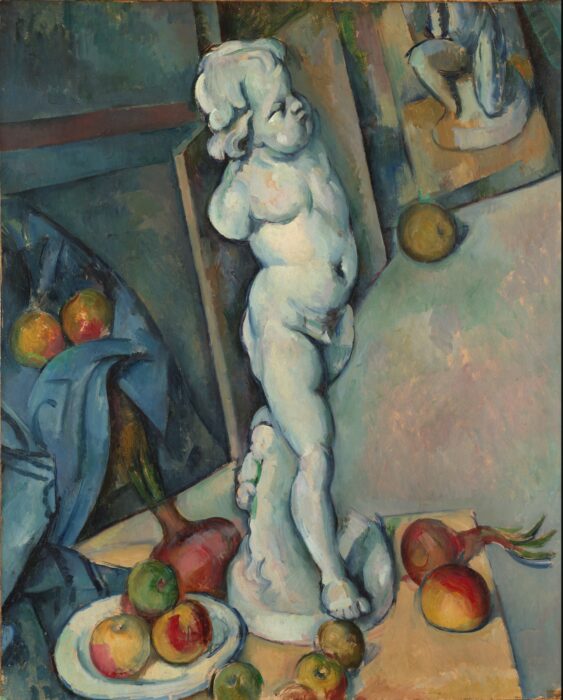 A statue of a Cupid set amongst apples and canvases