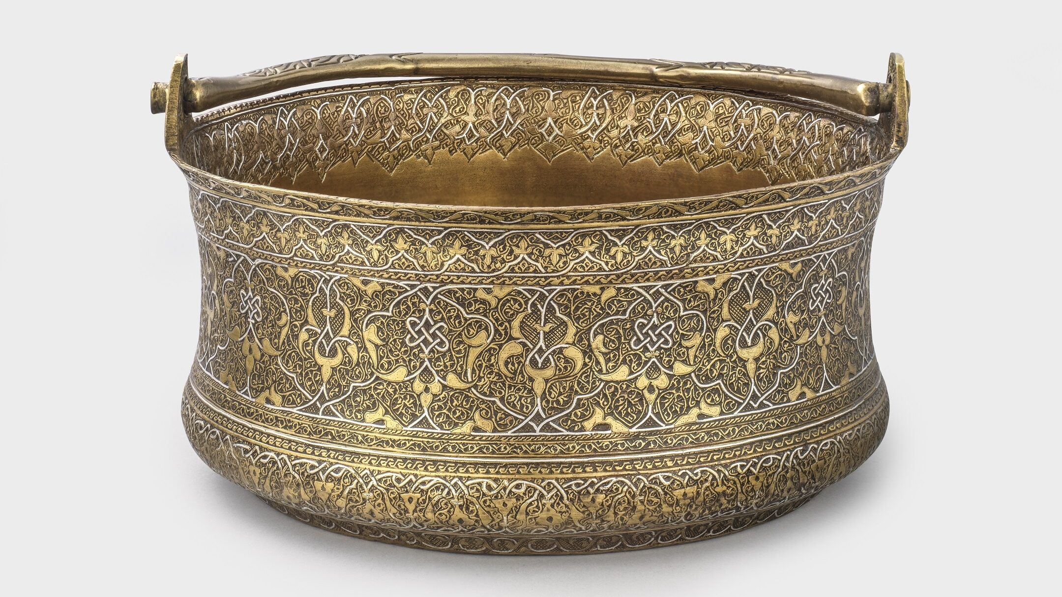 Bucket of engraved brass with silver inlay, the decoration continuing over the base, 1475-1550