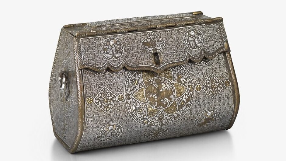 An intricate, oblong-shaped metal bag with front-closure. There are detailed illustrations at regular points across the front, and gold and silver inlays.