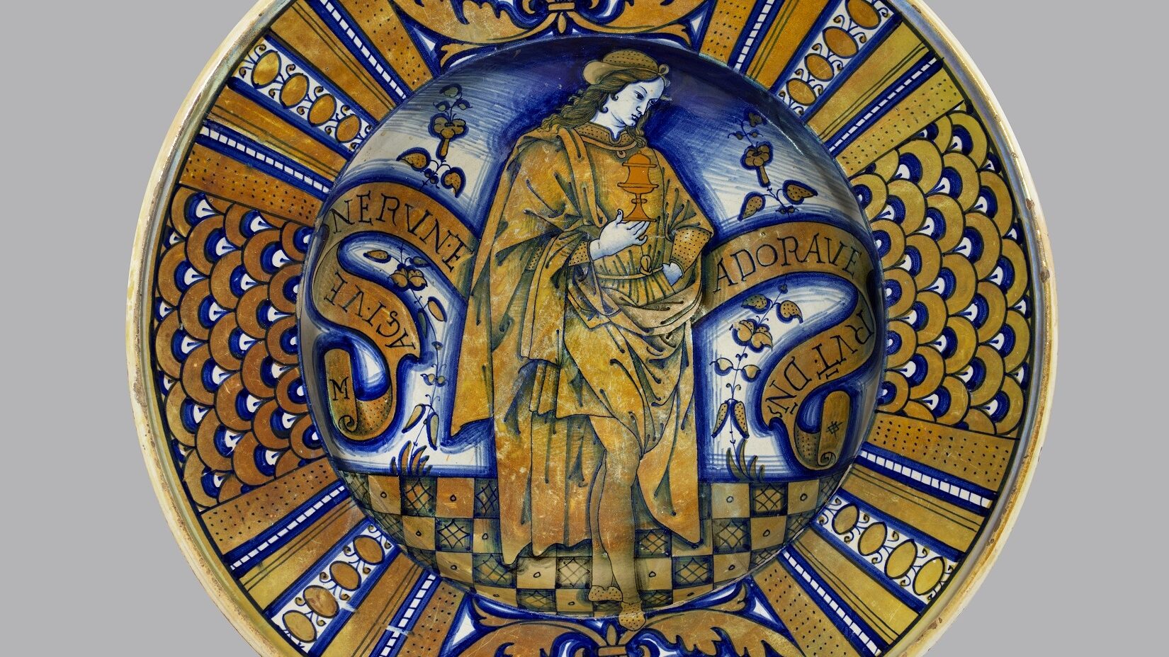 This beautifully painted dish shows the close ties between painting and pottery in Umbria, central Italy. The image is based on a detail from a painting by Pietro Vannucci, known as Perugino
