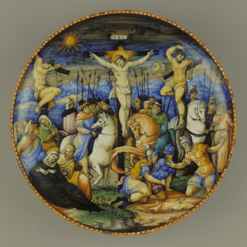 This dish is a painting in miniature, with an exceptional variety of colour, expressive figures, beautifully rendered textures and a dramatic crowd scene. The Christian imagery continues onto the back, with angels hovering in and out of clouds, carrying symbols of Christ’s Passion (Death and Resurrection)
