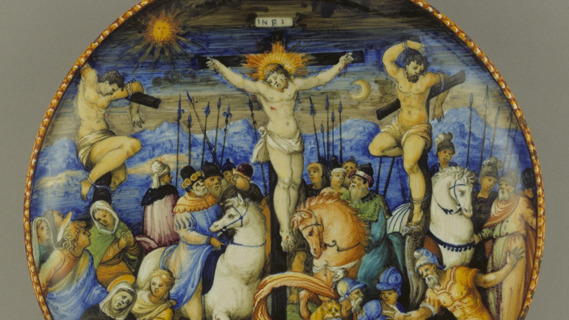 This dish is a painting in miniature, with an exceptional variety of colour, expressive figures, beautifully rendered textures and a dramatic crowd scene. The Christian imagery continues onto the back, with angels hovering in and out of clouds, carrying symbols of Christ’s Passion (Death and Resurrection)