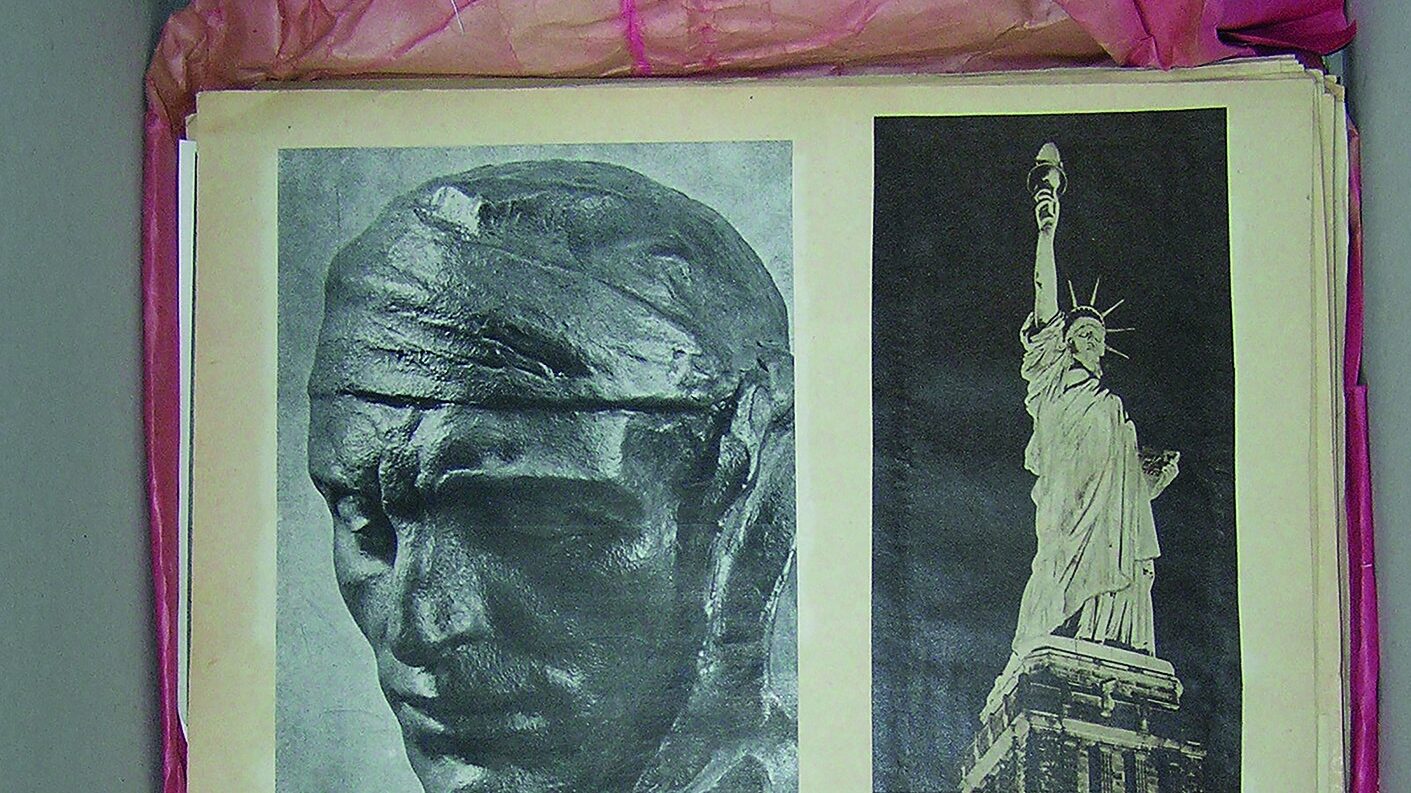 a photograph of an archive box containing a composite photograph of public sculptures