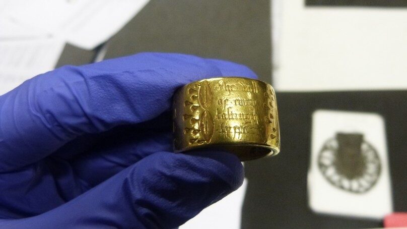 Photograph of someone handling a gold ring