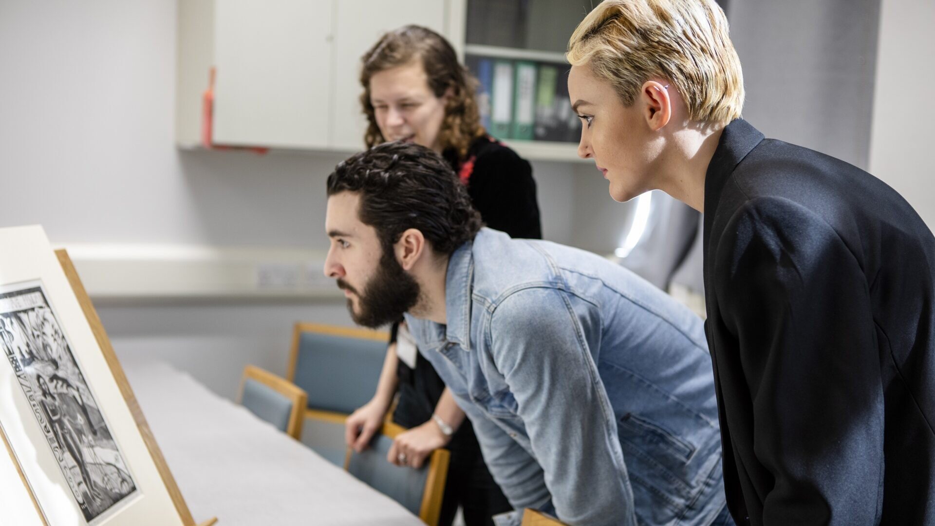 Group of students taking a closer look at an artwork in a seminar