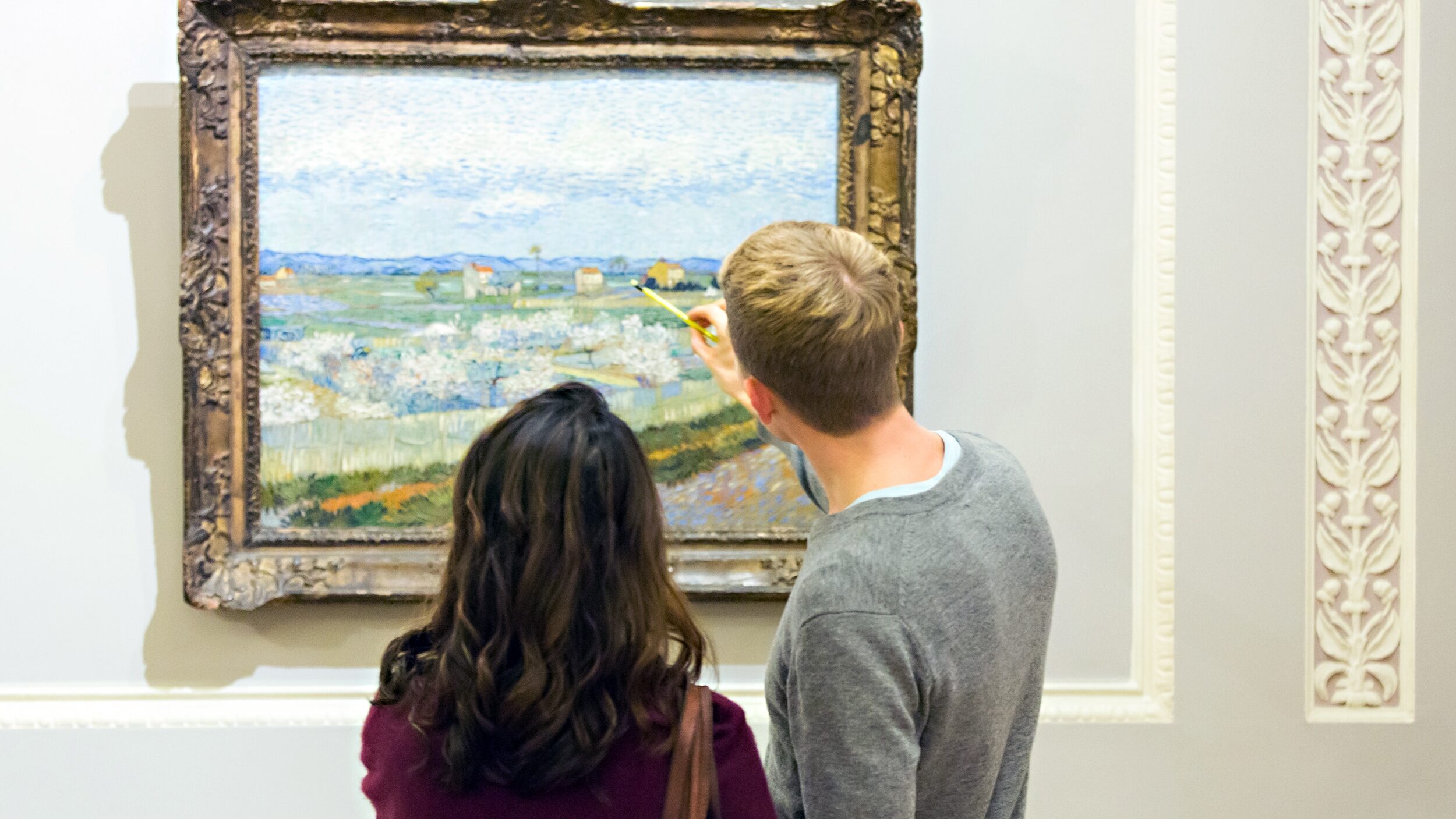 two people in a gallery in front of an impressionist painting
