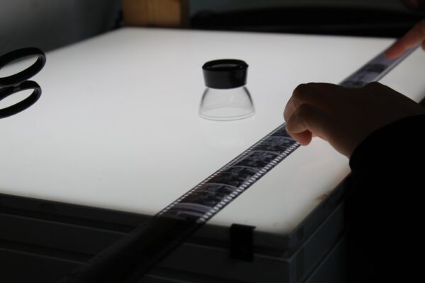 an analogue film strip on a light box with viewfinder