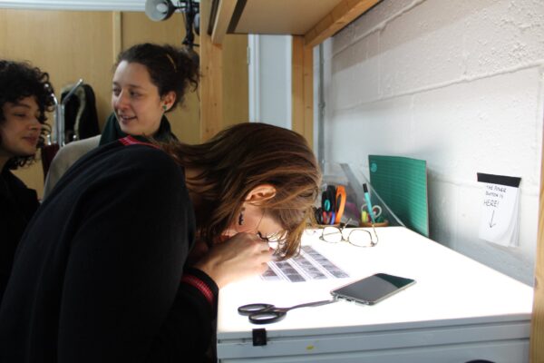 A person viewing a contact sheet on a light box.