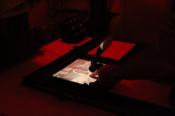 a slide enlarger projecting an image onto photosensitive paper in a dark room