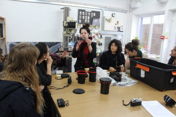 a group of students learning how to take photos using analogue film.