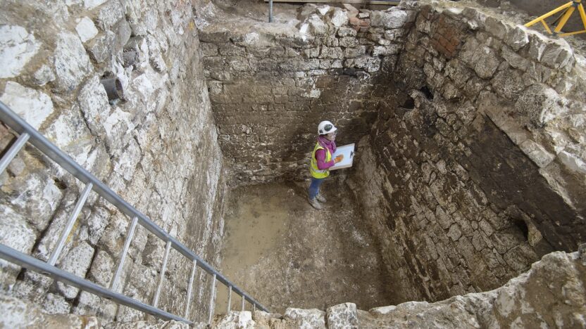 A MOLA archaeologist recording a 15th century cesspit uncovered in the basement of the Courtauld © MOLA
