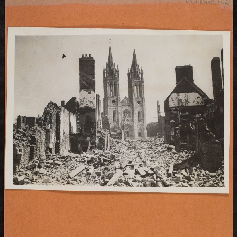 Black and white image showing an image from the Conway Library. Although St. Hilaire Du Harcourt suffered severe damage. The famed twin steeples of its church remain intact having escaped any serious damage.