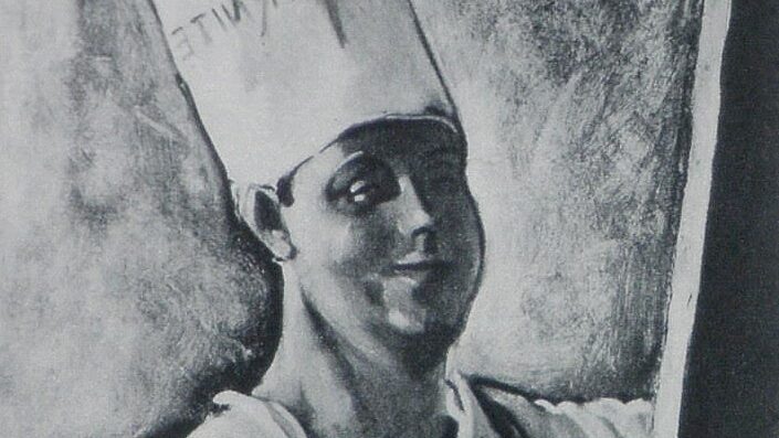 man in chefs hat in front of cabvas