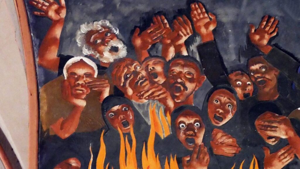 painting of faces on a wall with fire below