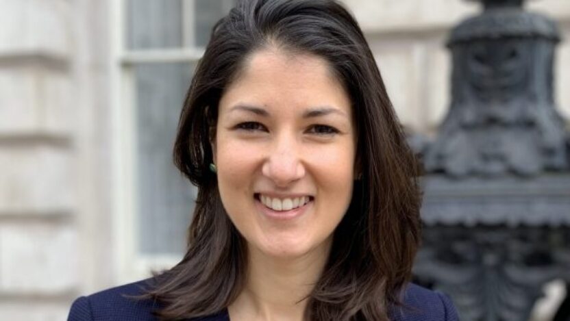 A headshot of Francesca Hewitt, wearing a blue blazer, outside The Courtauld Gallery at Somerset House.