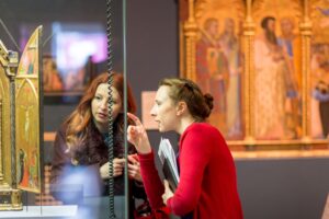 Two women looking at a work of art in a display case