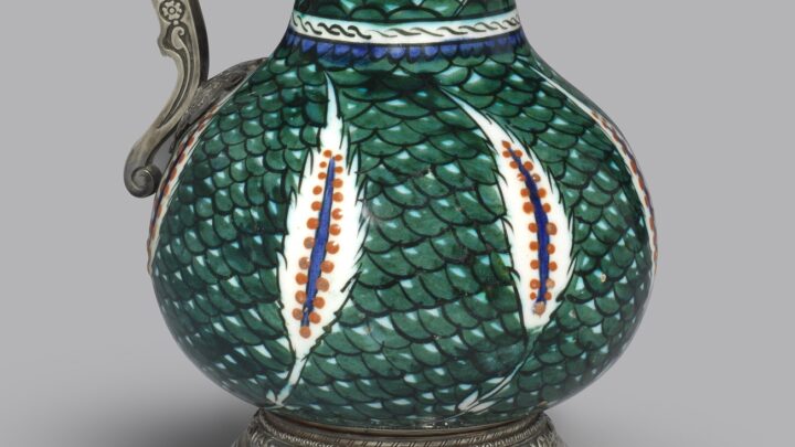 Ornate jug with saz leaves on a green fish-scale ground and an embellished curved silver handle and rim, Circa 1560