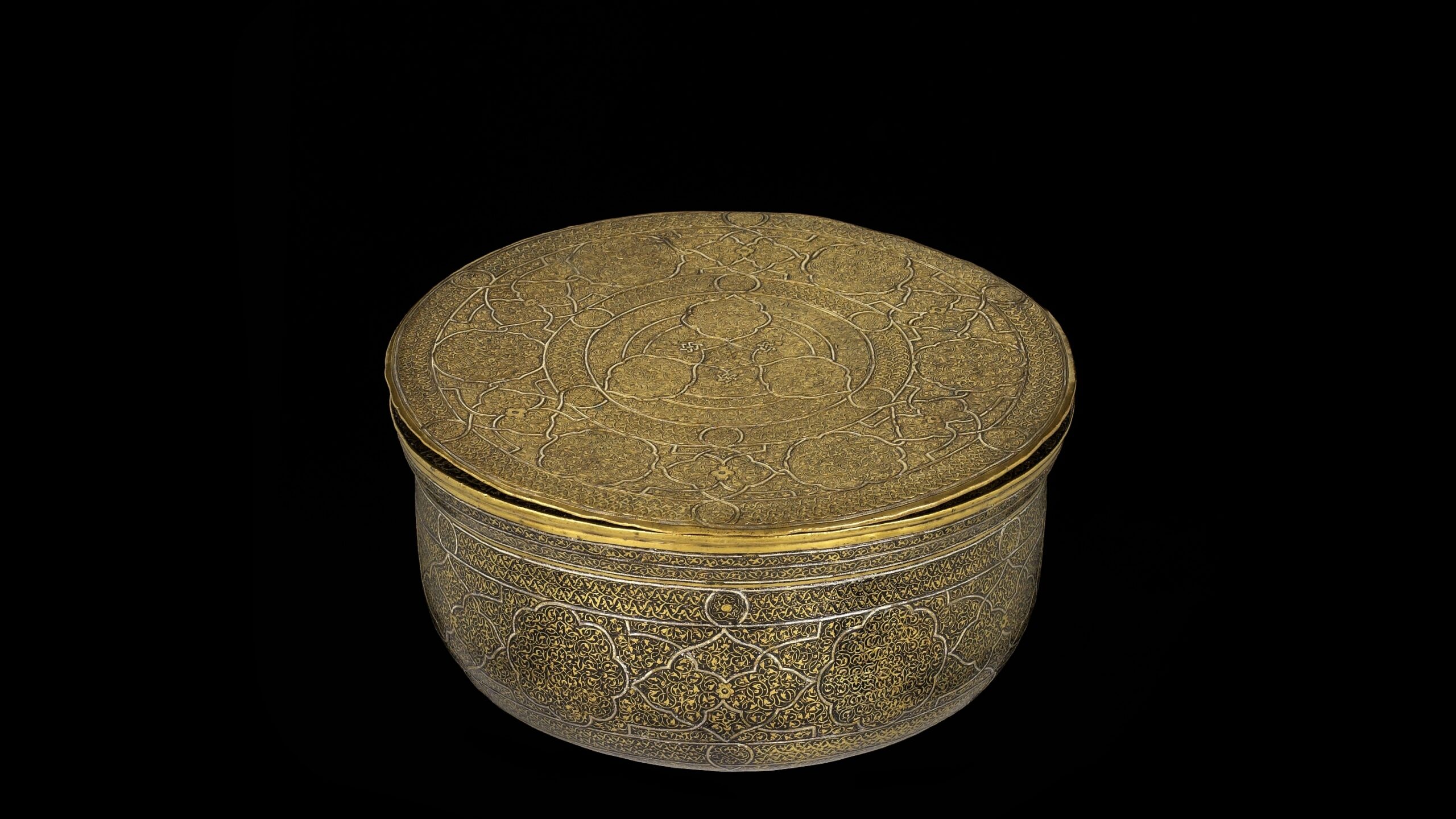 A golden, rounded bowl with a flat lid. Highly detailed engraving covers the entire bowl in traditional Islamic patterns.