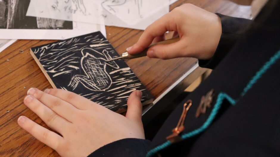 Children hands carving a board
