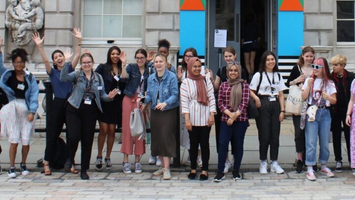 young people stood outside the Courtauld Institute of Art, waving hands and smiling
