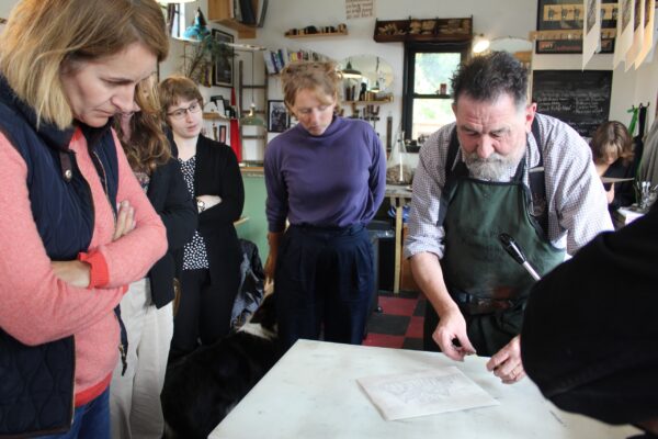 students watching a lino cut demo