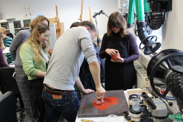 students learning how to grind pigments into oil paint