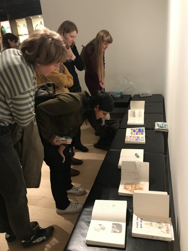 a group looking at sketchbook drawings at the Wellcome Trust