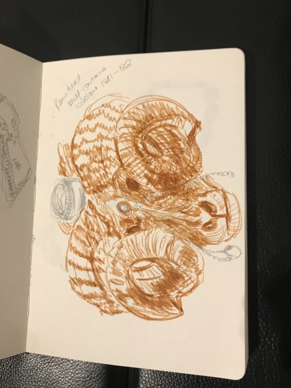 an abstract ink sketch in dark ochre in a sketchbook