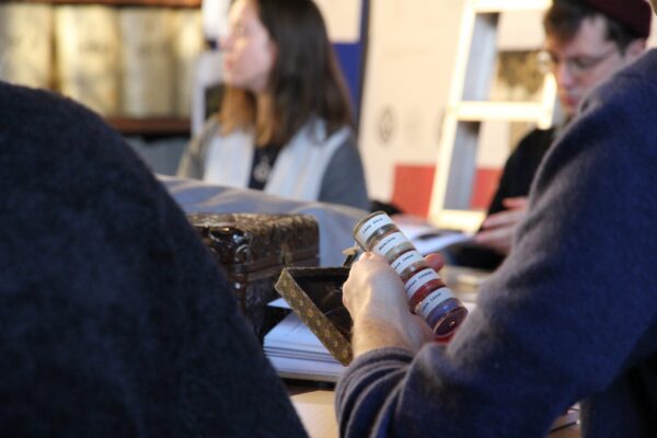 a student holding a vile of pigments