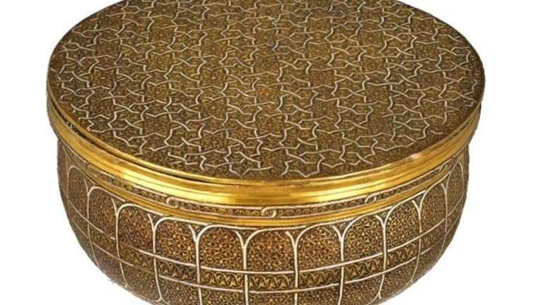gold metalwork bowl with intricate geometric pattern