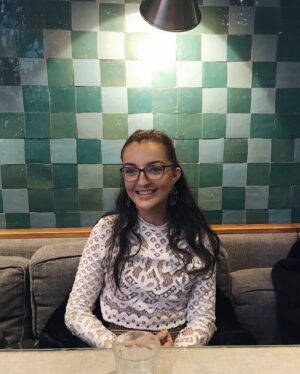 A young woman with glasses, indoors