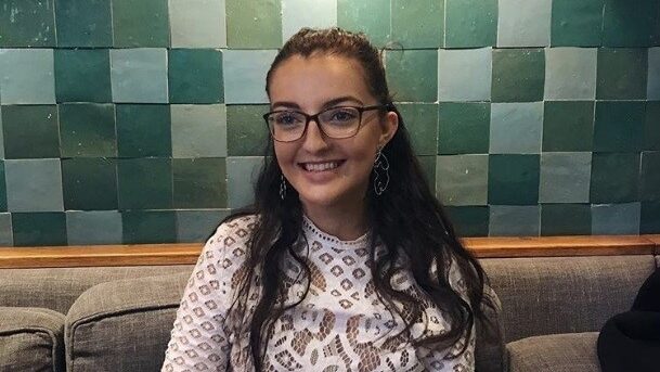 A young woman with glasses, indoors