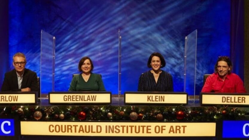 The Courtauld team in their booth at University Challenge 2021. Plastic screens separate each person, and their surnames are visible in University Challenge banners.