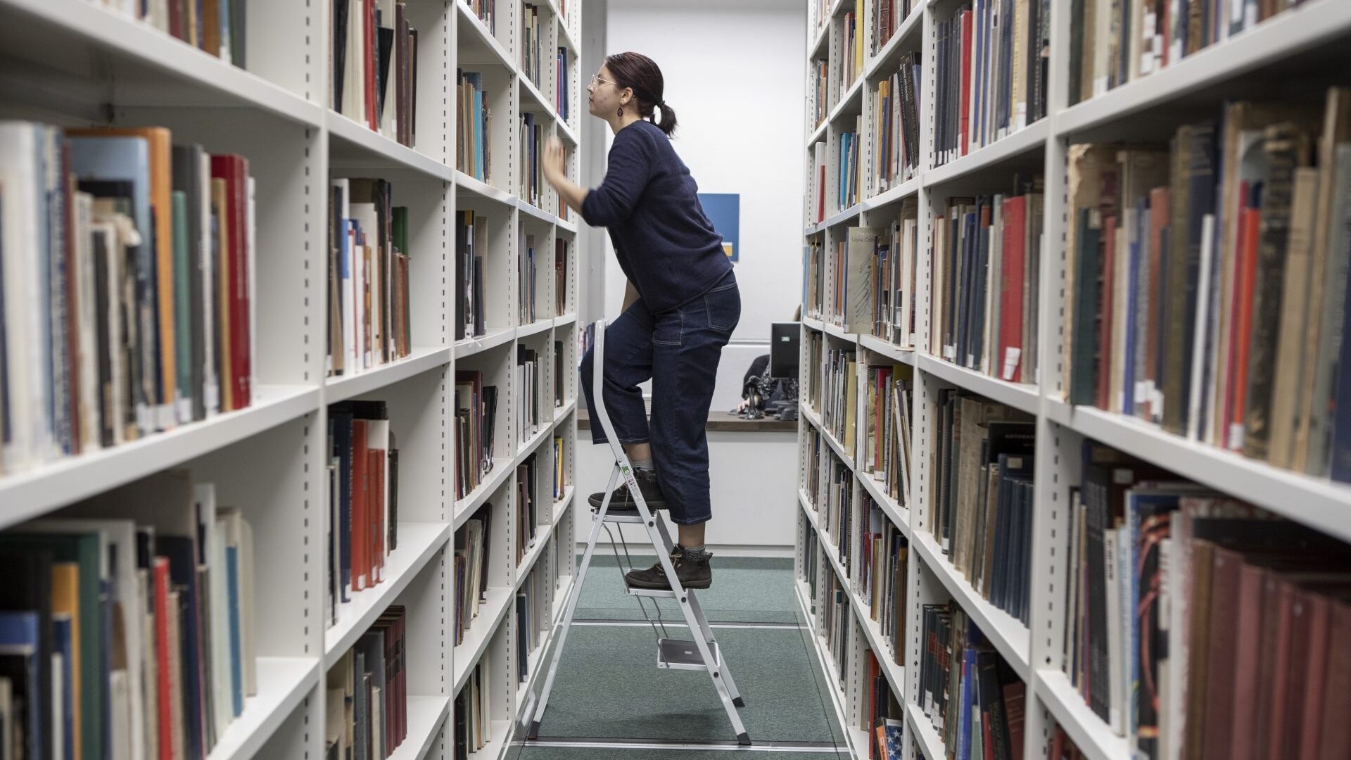 student using ladder in library