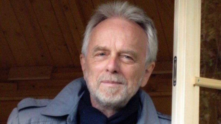 Photograph of man leaning on door