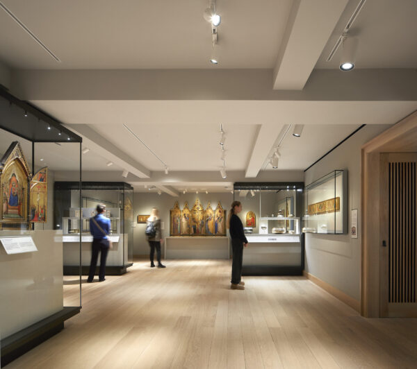 Three people standing in a gallery looking at objects from the Medieval and Early Renaissance period