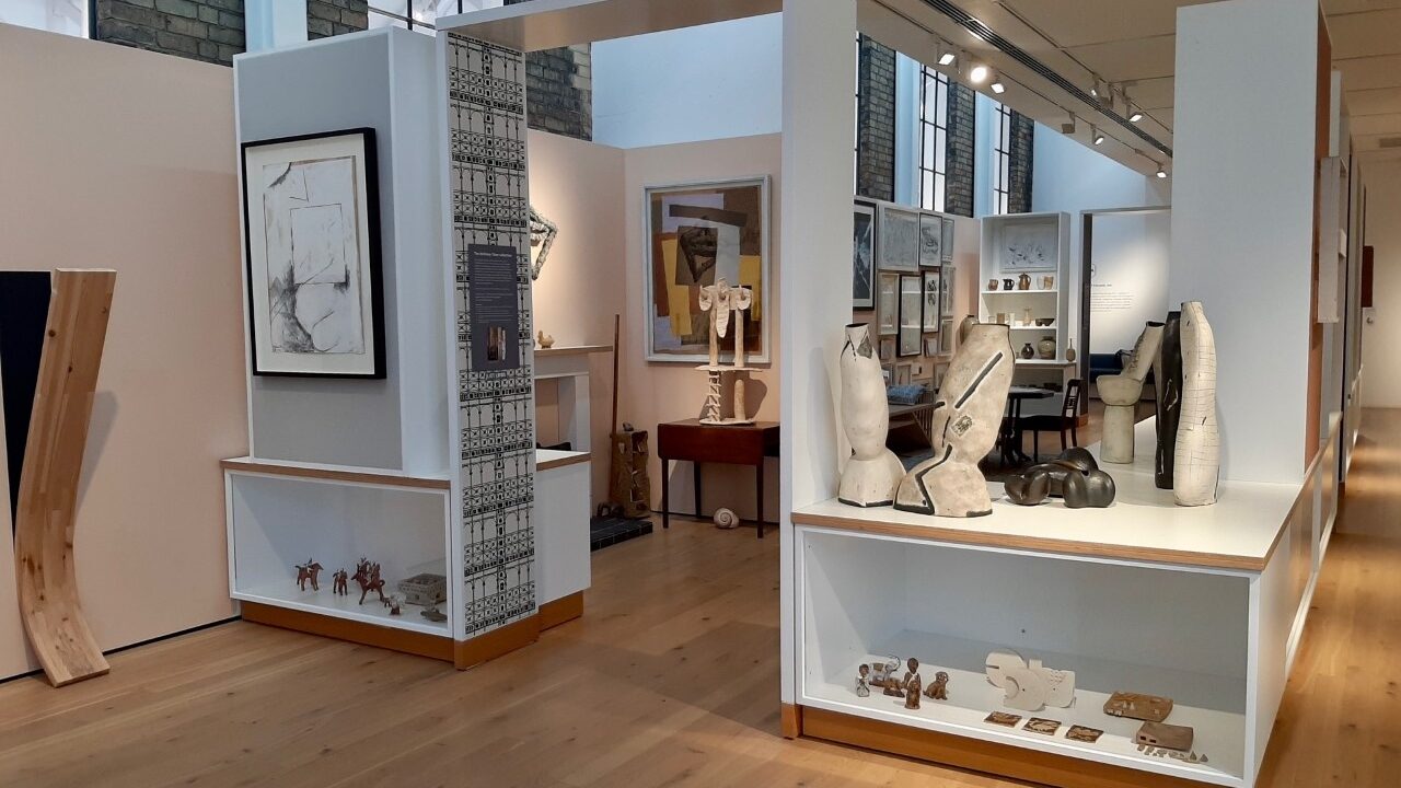 Photograph showing ceramics and paintings on display in a domestic setting.