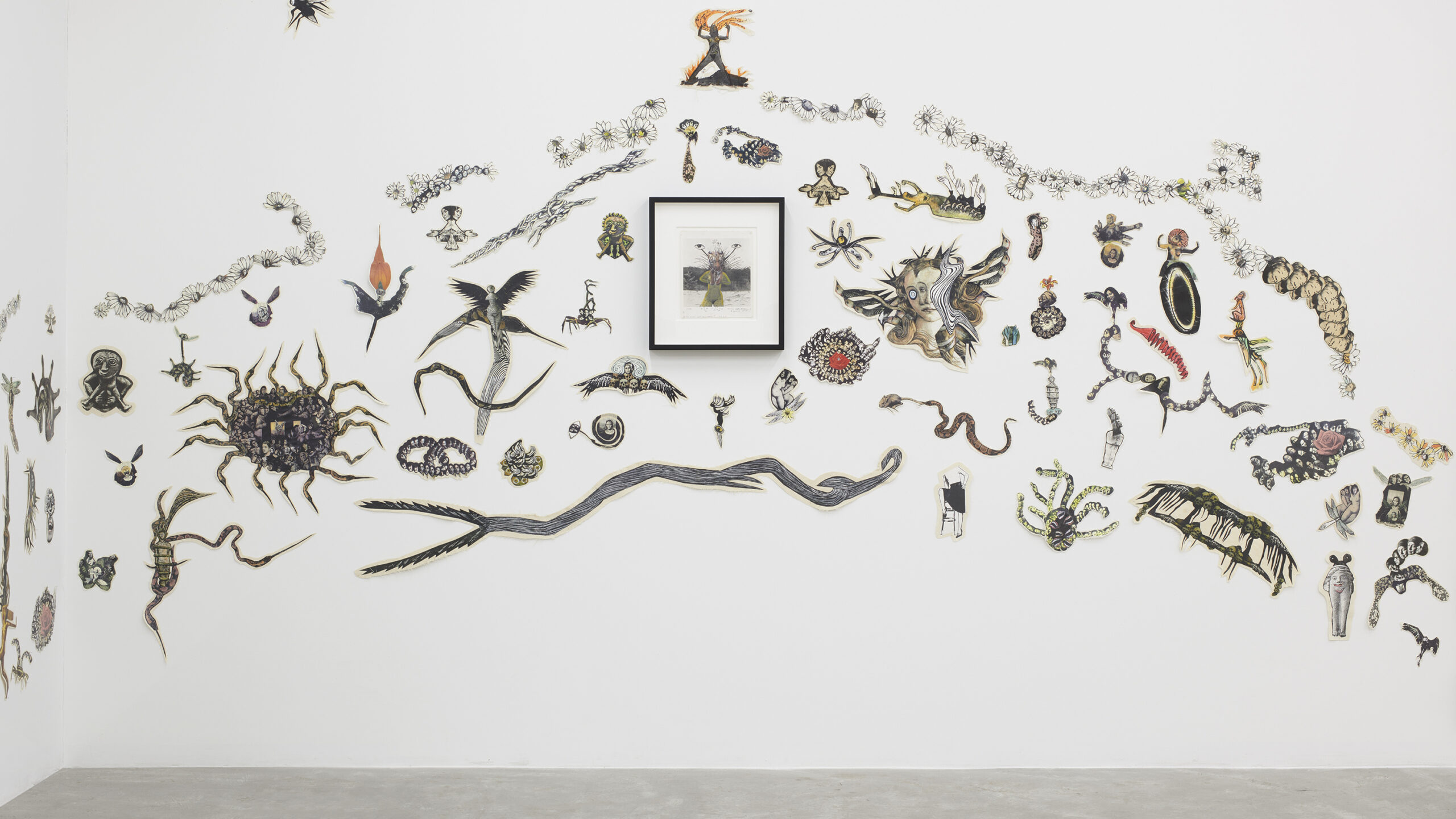 Photograph of an installed artwork, consisting of paper pictures of animals and insects stuck on a wall