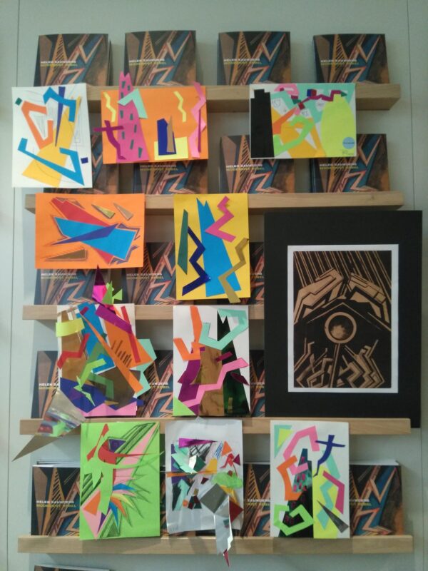 A series of colorful abstract drawings depicting geometrical shapes in different colors and shapes hanging on a wall next to each other