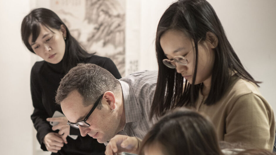 People looking closely at drawings