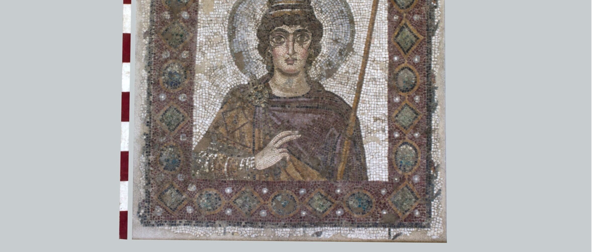 Photograph of a tiled mosaic depicting a female figure holding a stick, giving the sign of a blessing and with a halo around her head