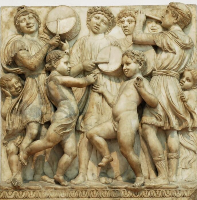 A marble relief showing a group of boys playing musical instruments.