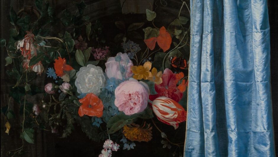 A bouquet of flowers half hidden behind a curtain.