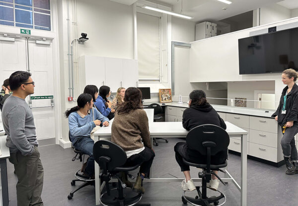 group of students sitting at a table in a classroom